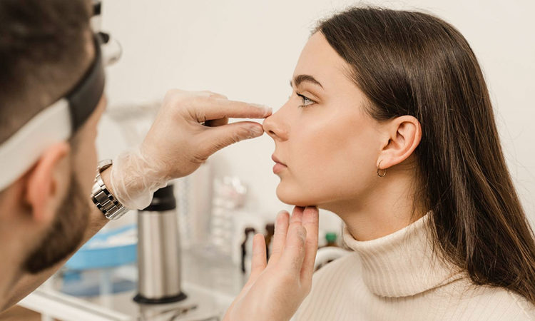Foto ilustrativa de uma mulher com um médico analisando seu nariz - Rinoplastia SPAR: conheça o método desenvolvido na Clínica Dewes 